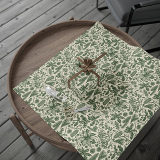 Evergreen Botanical Toile wrapping paper spread flat with a wrapped gift and brown bow