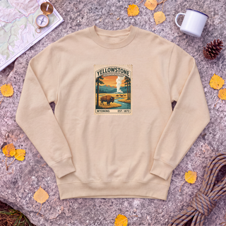 Pebble tan Yellowstone National Park sweatshirt with vintage bison and Old Faithful stamp, flat-lay on granite with trail map