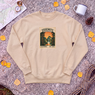 Pebble tan Yosemite National Park sweatshirt with vintage Half Dome stamp, flat-lay on granite with trail map and compass