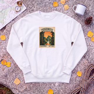 White Yosemite National Park sweatshirt with vintage Half Dome stamp, flat-lay on granite with trail map and compass