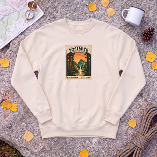 Natural cream Yosemite National Park sweatshirt with vintage Half Dome stamp, flat-lay on granite with trail map and compass
