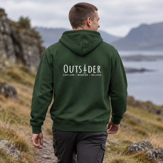 Man hiking a coastal trail in a forest green Outsider hoodie with Explore Wonder Belong on the back