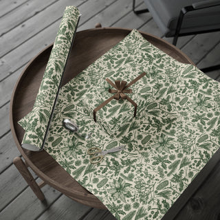 Roll of green pinecone and holly toile wrapping paper on a rustic wooden tray