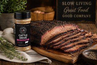 Cattle Drive beef and brisket seasoning beside sliced smoked brisket with peppery bark on a rustic wooden cutting board.