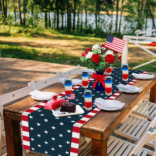 Outdoor table setting with a patriotic theme, including a tablecloth, flowers, and red, white, and blue decor.