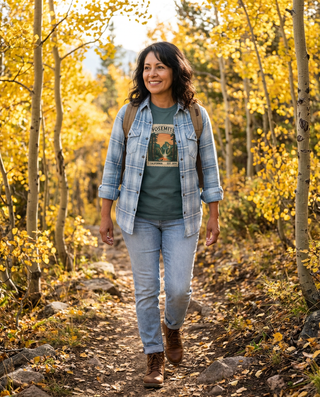 Woman wearing the pale blue plaid flannel open over a Yosemite National Park tee on an autumn aspen trail – Artisan Grove fall layering